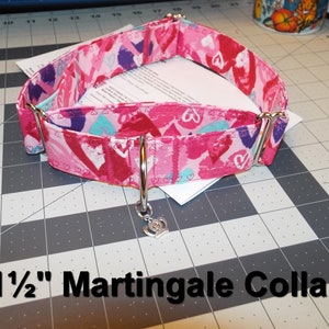 May include: A pink and white 1 1/2 inch martingale dog collar with a heart print and a silver crown charm.