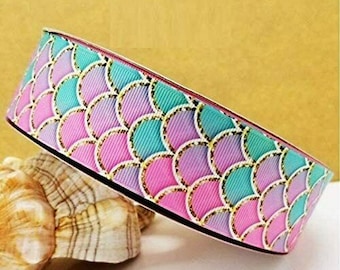 May include: A pink, purple, and turquoise ribbon with a mermaid scale pattern and gold glitter accents.