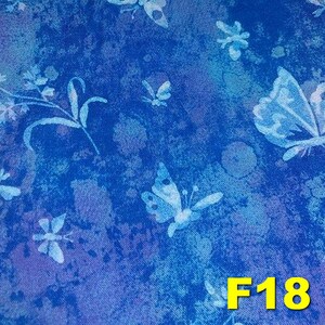 K&ouml;nnte beinhalten: Blauer Stoff mit einem wei&szlig;en Schmetterlingsmuster. Der Stoff hat eine strukturierte, leicht abgenutzte Optik. Der Text "F18" ist in Gelb in der unteren rechten Ecke des Stoffes gedruckt.
