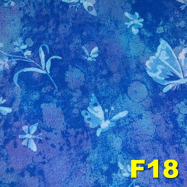 K&ouml;nnte beinhalten: Blauer Stoff mit einem wei&szlig;en Schmetterlingsmuster. Der Stoff hat eine strukturierte, leicht abgenutzte Optik. Der Text "F18" ist in Gelb in der unteren rechten Ecke des Stoffes gedruckt.