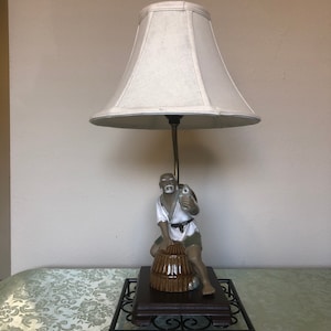 Lampada con figura dell&#39;uomo di fango orientale del pescatore su barile che tiene un pesce. Porcellane e mudware squisitamente dettagliati.