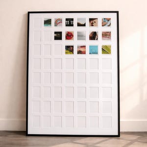 May include: A large white photo frame with a black border, designed to hold multiple small photos. Some photos are inserted, displaying various images. The frame is on a wooden floor.
