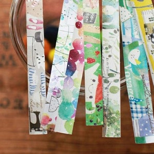 May include: Assortment of colorful washi tapes with various patterns and designs. The tapes feature watercolor illustrations of flowers, houses, and other whimsical elements. The text on the tapes includes "Bon Bon", "Finance", "Voyage", and "Go Green & Reuse".