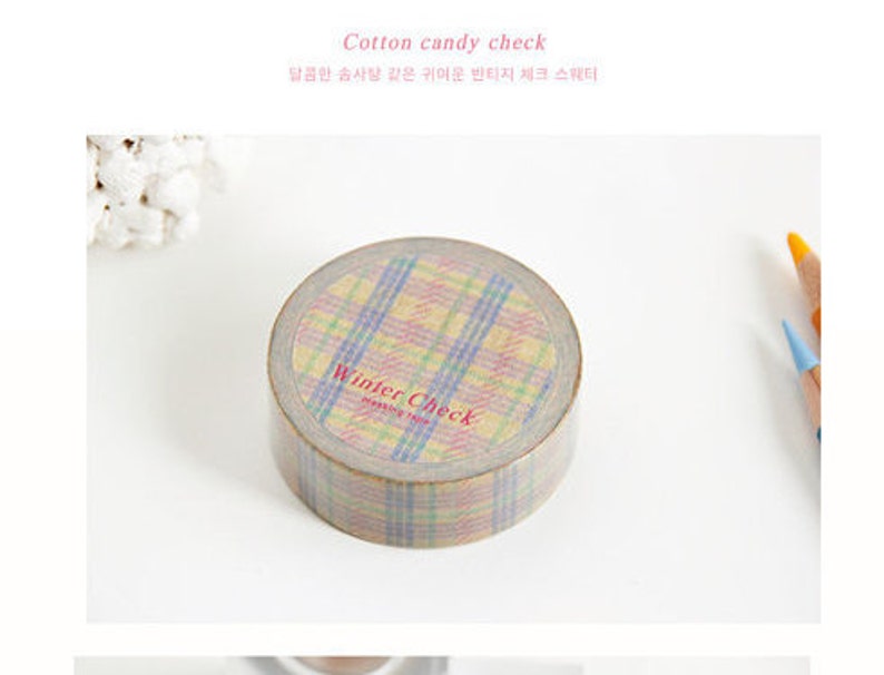May include: A roll of washi tape with a plaid pattern in shades of pink, blue, and yellow. The tape is labelled "Winter Check" and "masking tape".
