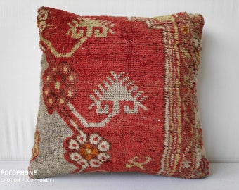 Peut inclure: Un coussin de décoration rouge et crème avec un motif tissé traditionnel. Le coussin a une forme carrée et est fait d'un tissu doux et texturé.