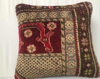 May include: A red, brown, and cream patterned throw pillow with a geometric design. The pillow is made of a soft, plush fabric.