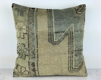 May include: A square throw pillow with a beige and blue patterned fabric. The fabric has a woven texture and features a geometric design.