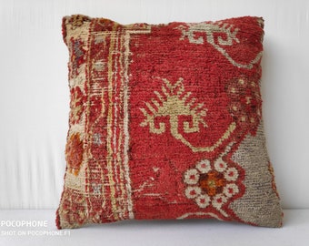 Peut inclure: Coussin carré rouge et beige avec un motif tissé texturé. Le coussin présente un champ central rouge avec des motifs géométriques beiges et une bordure beige. Le coussin est probablement fait d'un tissu durable.
