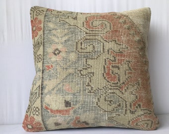 May include: A beige and orange patterned throw pillow with a woven texture. The pillow has a floral design with a geometric pattern.