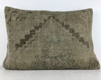 Könnte beinhalten: Ein rechteckiges Kissen mit einem beige-braunen geometrischen Muster. Das Kissen ist aus einem gewebten Stoff mit einer strukturierten Oberfläche.