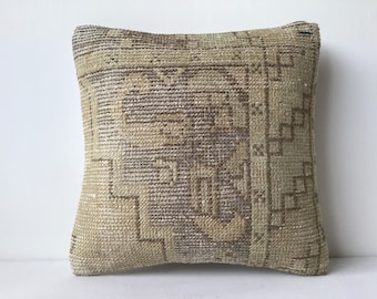 May include: A beige and brown patterned throw pillow with a woven texture. The pillow is square shaped and has a fringe border.