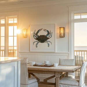 May include: A white dining room with a wooden table and chairs. A framed watercolor painting of a blue crab hangs on the wall. The room has large windows with views of the ocean.