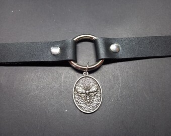 May include: A black leather choker necklace with a silver ring and a silver pendant featuring a detailed moth design.
