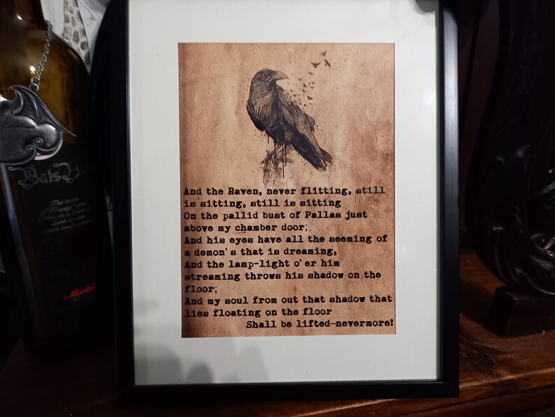 May include: Framed print featuring a detailed illustration of a raven perched on a branch, with text from a poem below. The artwork is set against a sepia-toned background, framed in black.