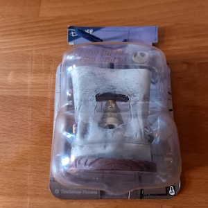 May include: A plastic-wrapped figurine of Jack Skellington from the Nightmare Before Christmas film. The figurine is in a white, skeletal-like structure with a brown base. The packaging has the Disney logo and the words "Special Edition" printed on it.