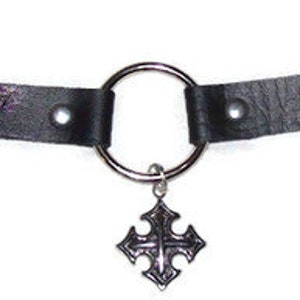 May include: Black leather choker with a silver ring and a silver cross pendant.