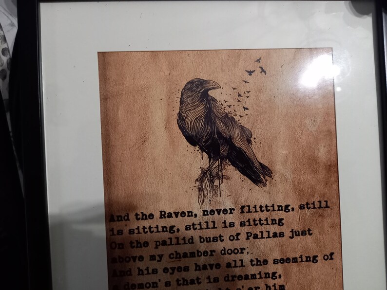 May include: Framed artwork featuring a detailed illustration of a raven perched on a branch, with a flock of birds flying away. The artwork is set against a textured, sepia-toned background with text from a poem.