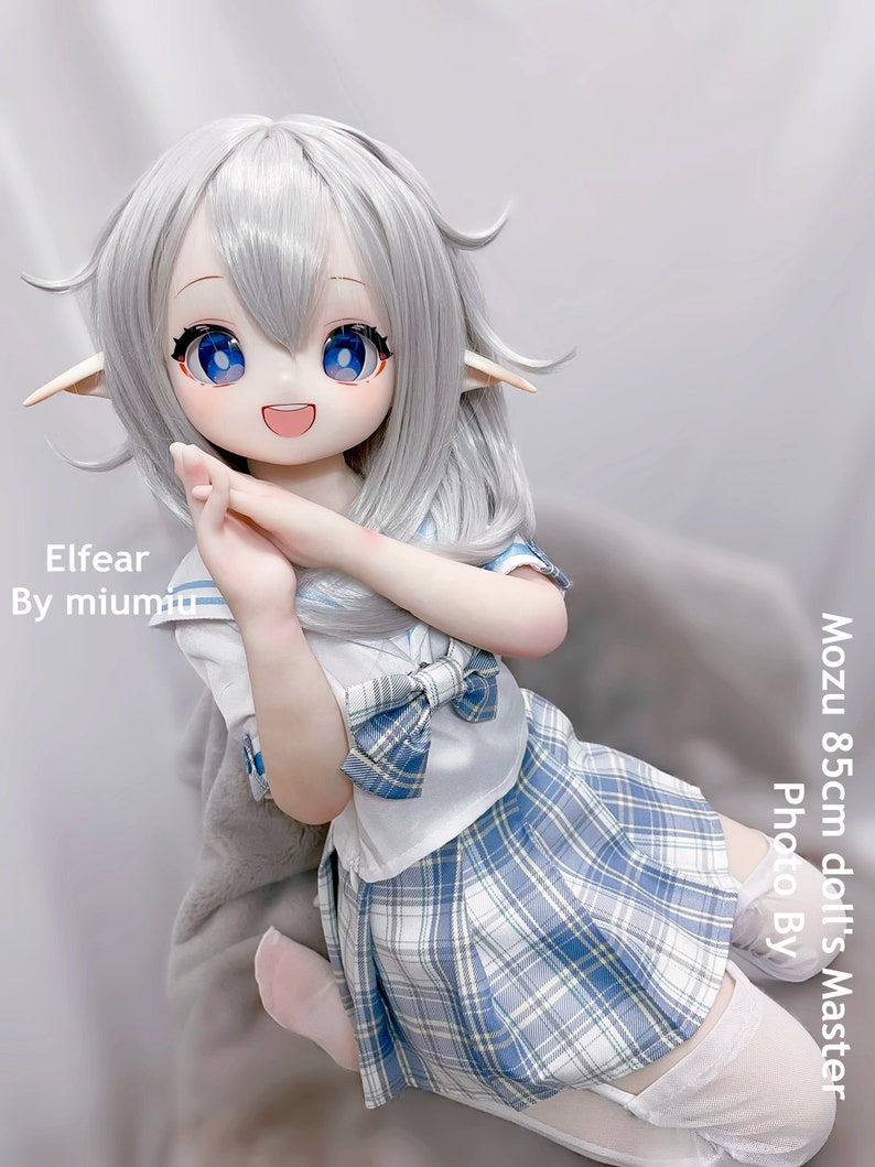 May include: A white haired doll with blue eyes wearing a white and blue plaid skirt and a white sailor collar shirt with a blue bow. The doll is 85cm tall and is called Elfear by miumu.