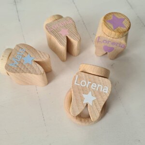 Könnte beinhalten: Vier hölzerne zahnförmige Boxen mit personalisierten Namen und einem Sternendesign. Die Namen sind "Lorena", "Mats" und "Lorena".