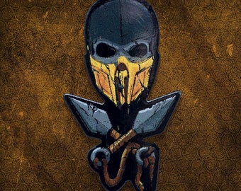 May include: A black and yellow skull mask with a dark blue background. The mask has a skull with a yellow jaw and a yellow and black design. The mask is surrounded by two crossed swords.