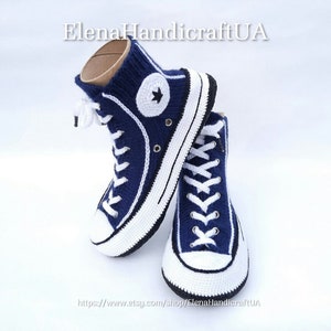 May include: A pair of blue and white knitted high-top sneakers with a white star on the side. The sneakers are made to look like Converse shoes.