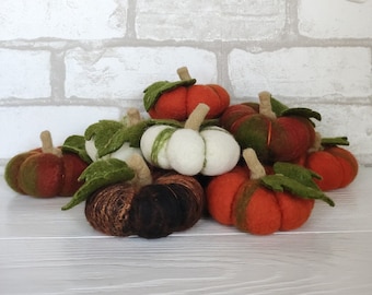 Alfiletero de lana afieltrada con forma de calabaza, color naranja, blanco y negro. Ideal para la decoración de la sala de costura. Regalo perfecto para sastres, costureras y modistas.