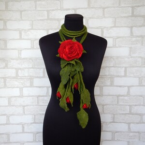 May include: A red felt rose with green felt leaves and stems, arranged as a long necklace.