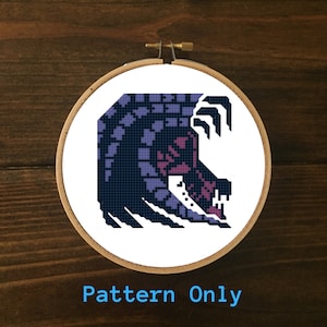 May include: A cross-stitch pattern of a purple and black monster with sharp teeth and claws. The pattern is in a round embroidery hoop.