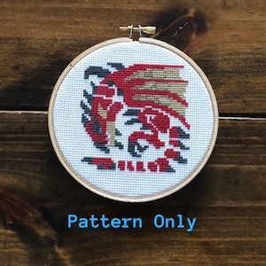 May include: A cross-stitch pattern of a red dragon with gold and black accents, framed in a wooden hoop. The pattern is labeled "Pattern Only".