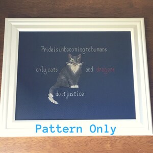May include: Cross stitch pattern featuring a black and white cat with the text "Pride is unbecoming to humans only cats and dragons do it justice". The pattern is framed and the text "Pattern Only" is written below the frame.