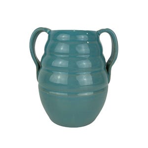 May include: A teal ceramic vase with two curved handles. The vase has a rounded base and a cylindrical body with horizontal ridges. The glossy finish reflects light, highlighting the teal colour.
