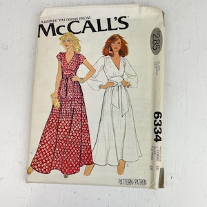 May include: Vintage McCall's sewing pattern showing illustrations of two long dresses. The pattern envelope is white with the McCall's logo and text. The dresses are a red patterned dress and a white dress. The envelope has the number 6334.