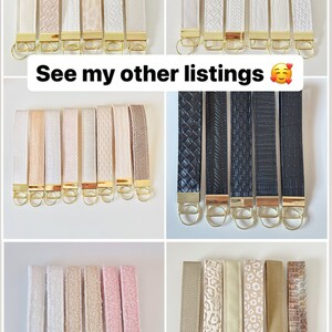 May include: Assortment of keychains with different patterns and colors, including white, beige, black, and pink. The keychains are made of leather and have gold-colored key rings. See my other listings.