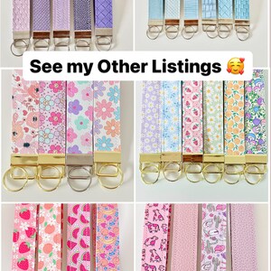 May include: A collection of colorful keychains with different patterns and designs. The keychains are made of fabric and have gold or silver key rings. The keychains feature various patterns, including floral, geometric, and animal prints. See my other listings.