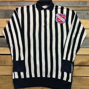 May include: Black and white striped long-sleeved shirt with a blue zip and a patch on the right side that says "A.H.A.U.S. 1977 1978"