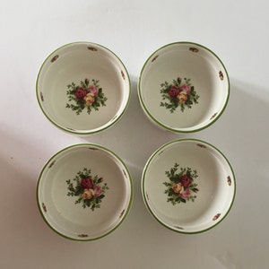 Peut inclure: Ensemble de quatre bols en céramique blanche avec des bords verts et des motifs floraux. Chaque bol présente un groupe de roses roses, jaunes et rouges avec des feuilles vertes.