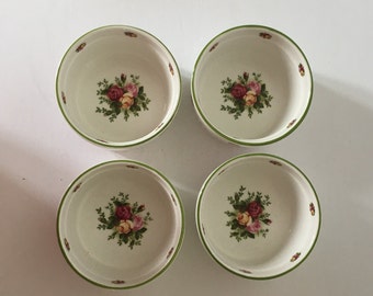 May include: Set of four white ceramic bowls with green rims and floral designs. Each bowl features a cluster of pink, yellow, and red roses with green leaves.