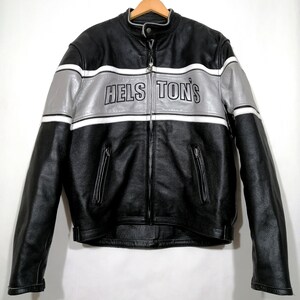 May include: Black leather motorcycle jacket with silver and white stripes across the chest. The jacket has the text "HELS TON'S" in black lettering. Features a stand-up collar, zippered pockets, and a full-length zipper.