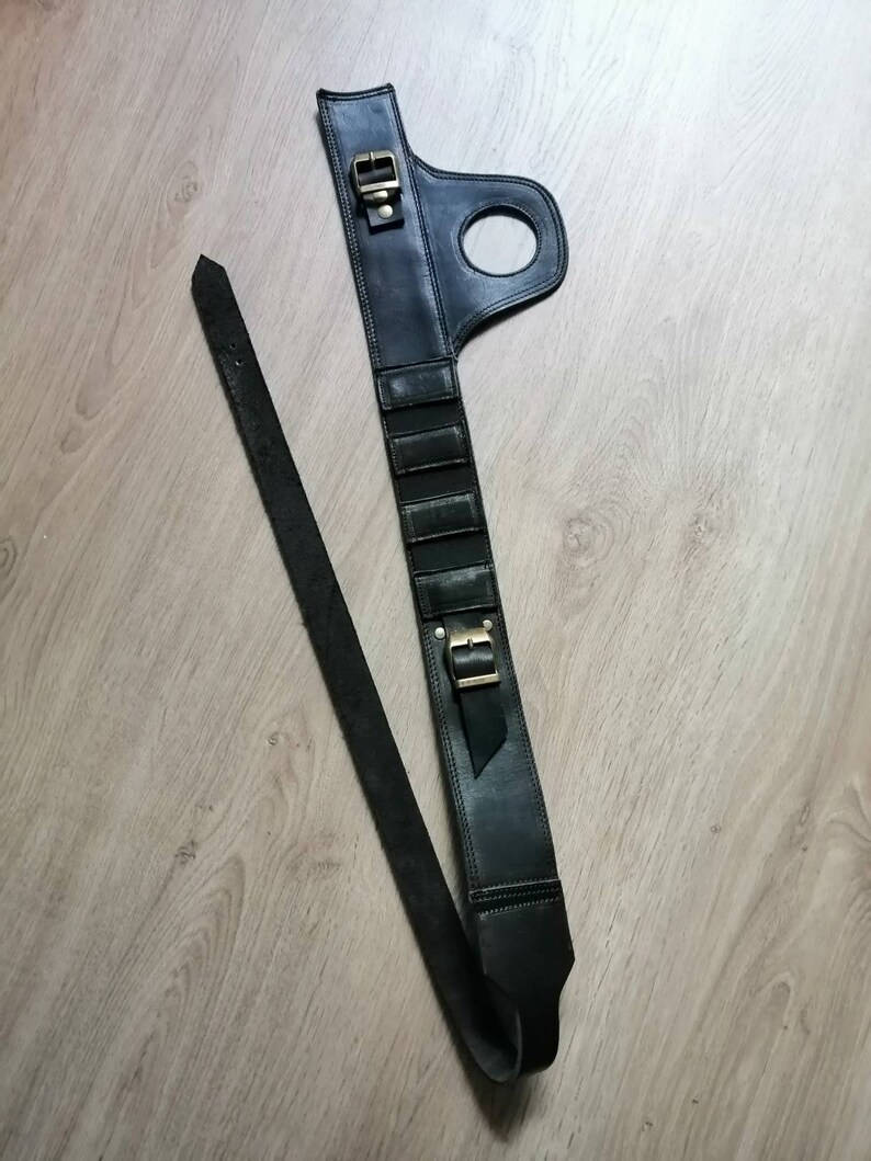 Puede incluir: Cintur&oacute;n de cuero negro con hebilla y un lazo en el lateral. El cintur&oacute;n tiene una correa que se puede ajustar para adaptarse a diferentes tama&ntilde;os.