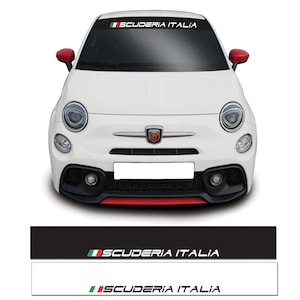 May include: A white car with red wing mirrors and a black and white windscreen banner displaying "SCUDERIA ITALIA" with the Italian flag. The car features a black front bumper with red detailing.