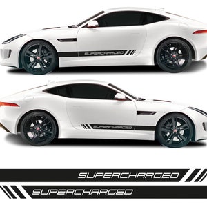 Könnte beinhalten: Zwei schwarze und weiße Vinyl-Aufkleber mit dem Aufdruck "SUPERCHARGED". Die Aufkleber sind für die Anbringung an der Seite eines Autos gedacht.