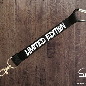 May include: Black lanyard with a silver carabiner clip and the text "LIMITED EDITION" in white lettering.