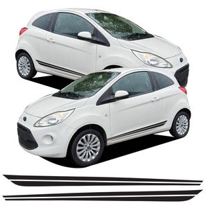 Puede incluir: Se muestran dos coches Ford Ka blancos con franjas laterales negras. Debajo de los coches hay dos calcomanías de franjas laterales negras. Los coches tienen neumáticos negros y llantas plateadas. El fondo es blanco.