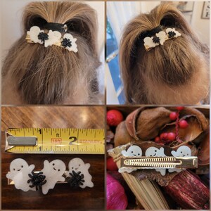 May include: Three white ghost hair clips with black spider accents. The clips are on a gold base and are about 2 inches long.