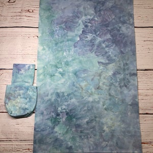 May include: A large, rectangular piece of fabric with a tie-dye pattern in shades of blue and green. A smaller, square piece of fabric with a similar tie-dye pattern is also included.