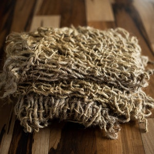 Puede incluir: Primer plano de una tela marrón tejida y texturizada. La tela está hecha de fibras naturales y tiene un aspecto áspero y rústico.