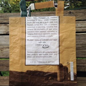 May include: A brown paper bag with a green and brown handle. The bag has a logo for CHS, a brand of agricultural products and services. The text on the bag reads "Payback is precision formulated to deliver proven, consistent results that give you a profit edge." and "PLANS? GOALS? OPPORTUNITIES? Let's talk."