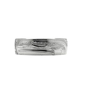 May include: A silver ring with a carved design. The ring has a wide band with a textured surface, featuring a pattern of flowing lines and shapes. The ring is displayed against a white background.