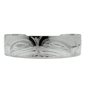 Puede incluir: Una pulsera de plata con un diseño grabado. La pulsera tiene una banda ancha con un patrón detallado de líneas y formas fluidas. El metal tiene una superficie pulida y reflectante.