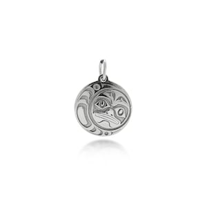 Peut inclure: Pendentif rond en argent avec un motif gravé détaillé d'un oiseau ou d'une créature stylisée. Le pendentif est doté d'une boucle pour une chaîne. Le design présente des lignes et des formes courbes, créant un aspect artistique unique.